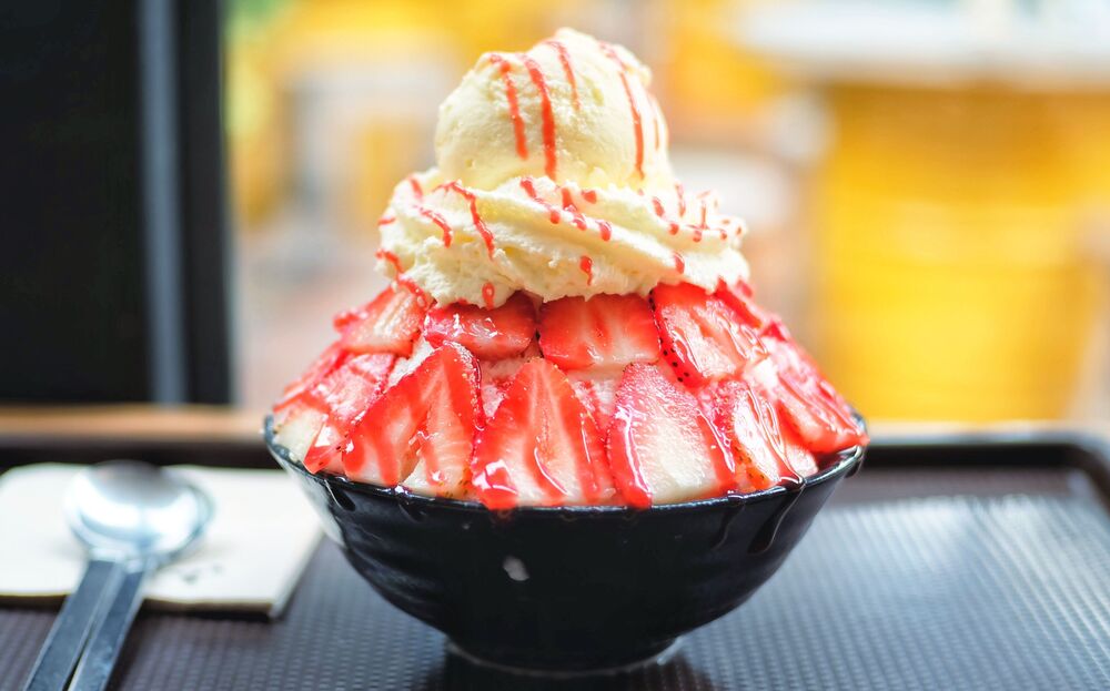 Shaved ice topped with strawberry and vanilla ice cream