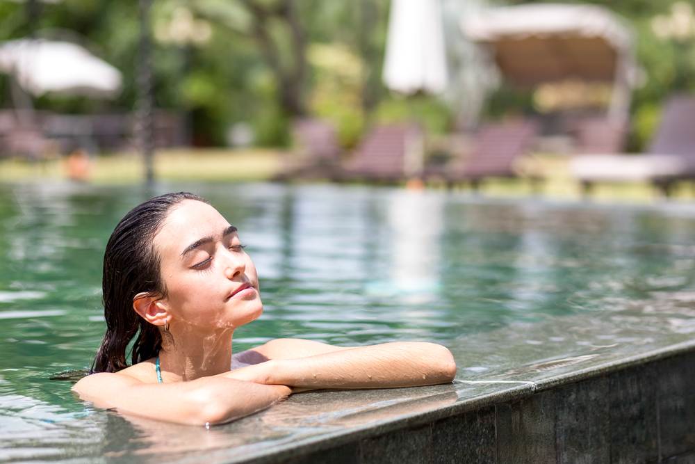 Woman relaxing by a swimming pool