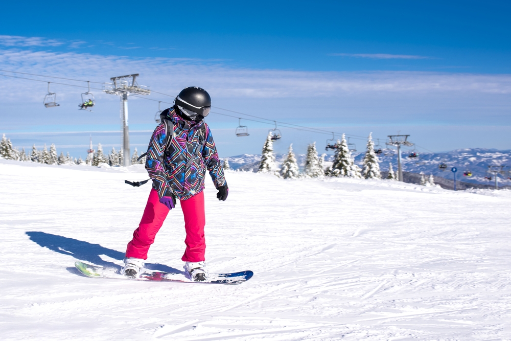 Orang bermain papan salji di resort ski