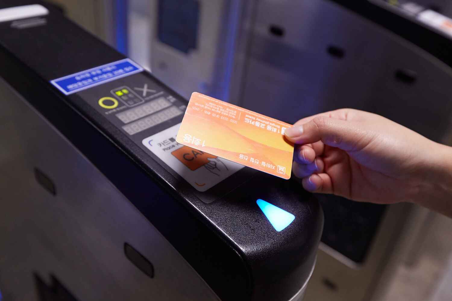 Escena de pulsación de una tarjeta de transporte en un lector de metro